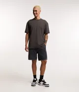 Bermuda de jean para hombre, color gris oscuro con efecto acid wash, cintura elástica con cordón de ajuste, bolsillos y tag aplicado.