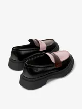 Mocasín de piel vacuna en color negro, con detalles en rosa claro y marrón oscuro en la parte superior. Cuenta con suela de goma gruesa y dentada, y plantilla OrthoLite reciclada.