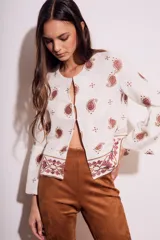 Blusa blanca con bordado de cachemir en negro, corte oversize y mangas acampanadas.