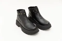 Borcego de cuero marrón con apliques de ojales metálicos y suela track.