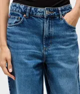 Pantalón de jean Blue Steel modelo baggy, de corte recto y amplio con cintura media. Presenta un lavado uniforme, cierre frontal con botón y cremallera, presillas para cinturón y bolsillos funcionales.