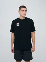 Remera de manga corta color beige, con cuello redondo y diseño holgado. Cuenta con un pequeño estampado rectangular en el pecho con motivo futbolero.