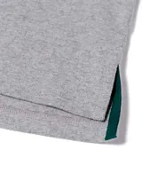 Remera polo gris melange de manga corta Caterpillar, con franjas horizontales en tonos verde oscuro y menta en el pecho, cuello camisero con botones y parche de silicona con logo.