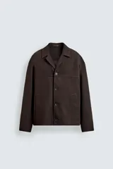 Sobrecamisa de corte regular confeccionada en tejido de mezcla de lyocell y algodón. Presenta cuello con solapas de muesca, cierre frontal con botones, mangas largas con puños abotonados y bolsillos de vivo en la parte frontal.