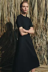 Vestido midi de cuello redondo y manga corta abullonada con terminación elástica. Presenta un diseño de corte entallado en el torso con falda evasé y cierre de cremallera oculta en la espalda.