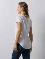 Blusa blanca de modal con cuello redondo y escote en V. Tiene apliques de crochet en el escote y los hombros.