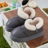 Pantuflas botitas color tostado con diseño acolchado y plataforma, forradas con corderito sintético blanco en el interior y el cuello. Cuentan con una pequeña etiqueta decorativa en el lateral.