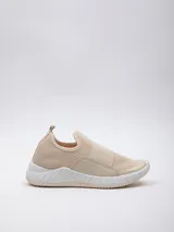 Zapatilla beige de tela tejida, con piezas de goma en los laterales y pieza elástica sobre el empeine. Plataforma texturada de 4 cm de alto.