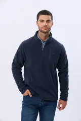 Buzo de polar azul con cuello alto y cierre frontal parcial. Presenta un bolsillo vertical con cierre en el pecho y bolsillos laterales, ideal para abrigo en climas fríos.