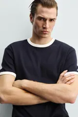 Camiseta de corte regular fit, color gris oscuro, con cuello redondo y bordes de mangas en color azul marino a contraste.