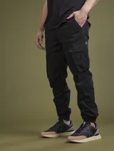 Pantalón cargo negro con bolsillos laterales con solapa, corte ajustado y tobillos elastizados.