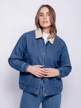 Campera de jean azul con cuello de corderito color crema, cierre frontal con botones metálicos, dos bolsillos delanteros y elástico en el bajo.