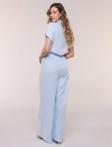 Conjunto de dos piezas confeccionado en lino, de estilo casual safari. Incluye camisa de manga corta con cuello camisero con bordado festoneado, abotonadura frontal y bolsillos en el pecho; y pantalón palazzo de tiro alto con bolsillos y cinturón con hebilla metálica dorada.