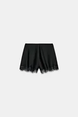 Shorts de tiro alto confeccionados en tejido satinado, con cintura elástica y detalle de aplicación de encaje en el ruedo.