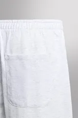 Pantalones cortos tipo jogger de corte relajado confeccionados en tejido de algodón. Presentan cintura elástica con cordón interior, bolsillos frontales en la cadera y un bolsillo trasero de plastrón.