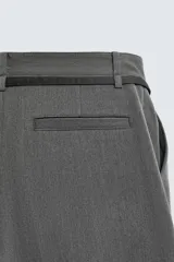 Pantalón de corte balloon fit en color gris, confeccionado en tejido con viscosa. Presenta pliegues frontales, cintura con cinturón integrado a contraste, bolsillos laterales y bolsillos traseros de vivo.