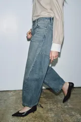 Jeans de tiro medio con corte balloon leg y largo al tobillo. Presenta diseño de cinco bolsillos, cintura con trabillas y cierre frontal con cremallera y botón metálico.