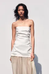 Vestido midi de escote palabra de honor con cuerpo drapeado y falda de tejido combinado con caída fluida. Presenta cierre con cremallera oculta.