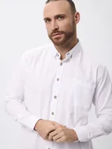 Camisa de corte clásico confeccionada en tejido oxford de algodón, con cuello abotonado, cierre frontal con botones y bolsillo en el pecho.