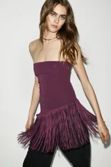 Top bandeau blanco con escote palabra de honor y bajo asimétrico con flecos.