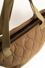 Bolso tipo tote bag color marrón con diseño capitonado de ondas, asas largas y placa metálica con el logo de la marca.