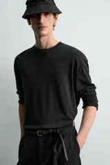 Camiseta relaxed fit de manga larga y cuello redondo, confeccionada en tejido de mezcla de algodón y lino, en color negro.