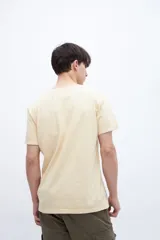 Remera color beige claro de manga corta con bolsillo en el pecho.