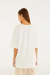 Remerón oversize de cuello redondo, color blanco, de manga corta y corte amplio con abertura lateral.