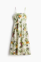 Vestido midi de color blanco con estampado botánico de frutas y flores, escote cuadrado, breteles finos y falda con vuelo.