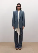 Blazer de corte sastrero en color azul petróleo, con diseño de doble botonadura, solapas clásicas y hombreras estructuradas.