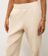 Pantalón jogger deportivo color bordó, con cintura elástica, bolsillos laterales y puños ajustados. Presenta recortes canelados en los laterales que aportan textura y diseño al modelo.