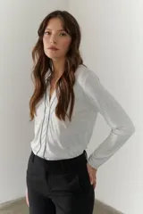 Remera manga larga color borgoña con cuello en V y costuras decorativas verticales.