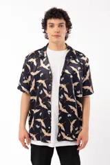 Camisa negra con estampado de grullas y flores, de manga corta y corte relajado, con cuello tipo sastre.