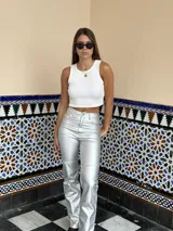 Pantalón plateado de eco cuero, de corte recto y tiro alto.