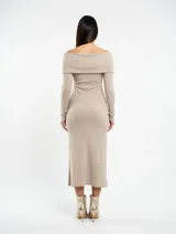 Vestido midi de punto color camel, con escote estilo bote con solapa caída y mangas largas ajustadas. Presenta un corte entallado que sigue la silueta del cuerpo.