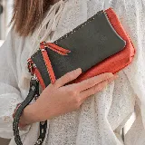 Monedero de cuero color verde y naranja, con doble compartimento con cierre y tarjetero interno.