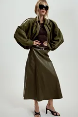 Chaqueta de efecto ante color marrón claro, con cuello solapa, manga larga con trabillas en los hombros y bajo abullonado. Cierre frontal con cremallera y botones ocultos por solapa.