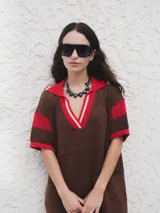 Remerón tejido de punto color azul marino con calados, cuello estilo camisa en verde oscuro con rayas blancas y verdes, y logo bordado en blanco en el pecho.