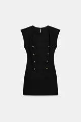 Vestido corto de estilo militar en color negro, con cuello redondo, hombreras y manga sisa. Presenta un diseño frontal con falsos botones dorados dispuestos en filas horizontales. Cierre lateral con cremallera oculta y abertura en la espalda con botón.