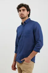 Camisa azul de manga corta, con cuello abotonado y bolsillo en el pecho.