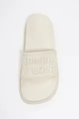 Sandalia tipo pala color blanco crudo, con plataforma, suela dentada y logo en relieve en la tira frontal.