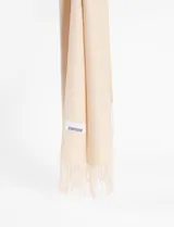 Pashmina de textura suave en color beige, con diseño liso y terminación de flecos en los extremos. Incluye etiqueta de marca cosida.