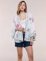 Kimono de poliéster blanco con diseño abierto, mangas amplias y bordados coloridos de motivos florales y arabescos, con terminaciones en ondas de hilo verde.