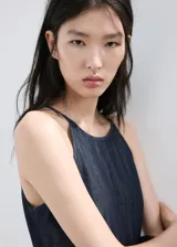 Mono largo de denim color azul oscuro, con escote halter y diseño recto en las piernas.