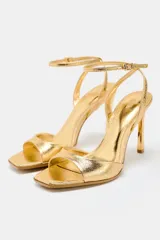 Sandalias negras de tacón fino con efecto craquelado, tira ancha en la parte delantera, cierre mediante hebilla metálica en la pulsera del tobillo y acabado en punta cuadrada.