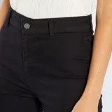 Pantalón de jeans negro de corte skinny, tiro alto y largo hasta el tobillo.