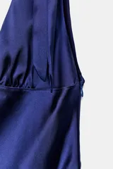 Vestido midi satinado color marrón, con escote en V y tirantes anchos ajustables con lazada en los hombros. Presenta cierre lateral con cremallera oculta.