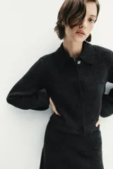 Falda corta de tiro medio confeccionada en tejido de punto, con diseño de silueta recta, cintura con trabillas y detalles de falsos bolsillos de vivo en la parte frontal.