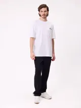 Remera blanca de manga corta con gran estampado negro del logo de Rusty en la espalda y corte holgado.