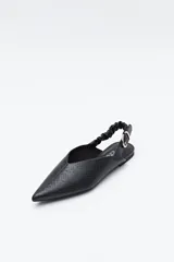 Zapato destalonado de punta fina, color negro, con base baja y tira trasera elástica con hebilla metálica ajustable. Diseño minimalista.